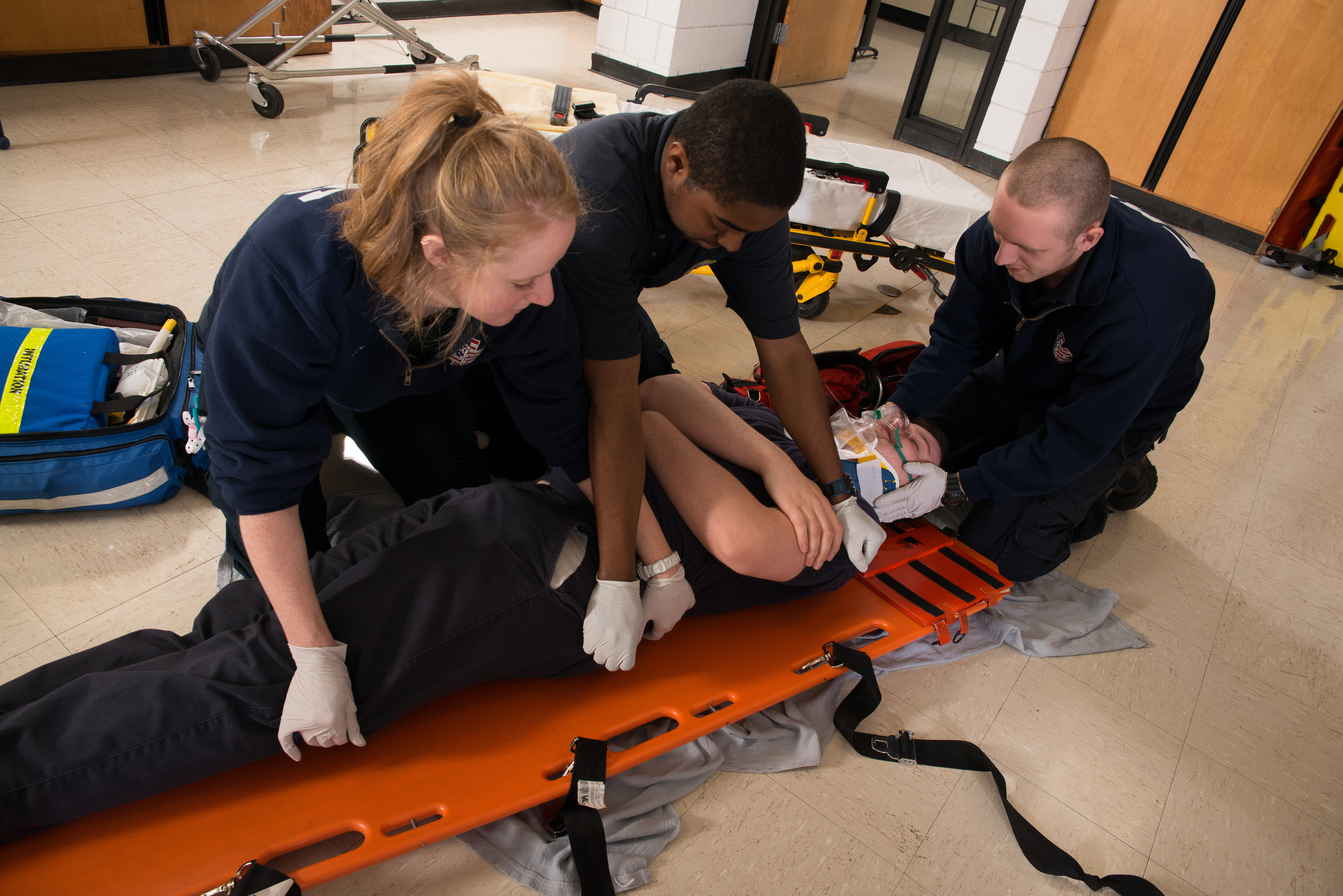 Three EMT students working on patient on stretcher